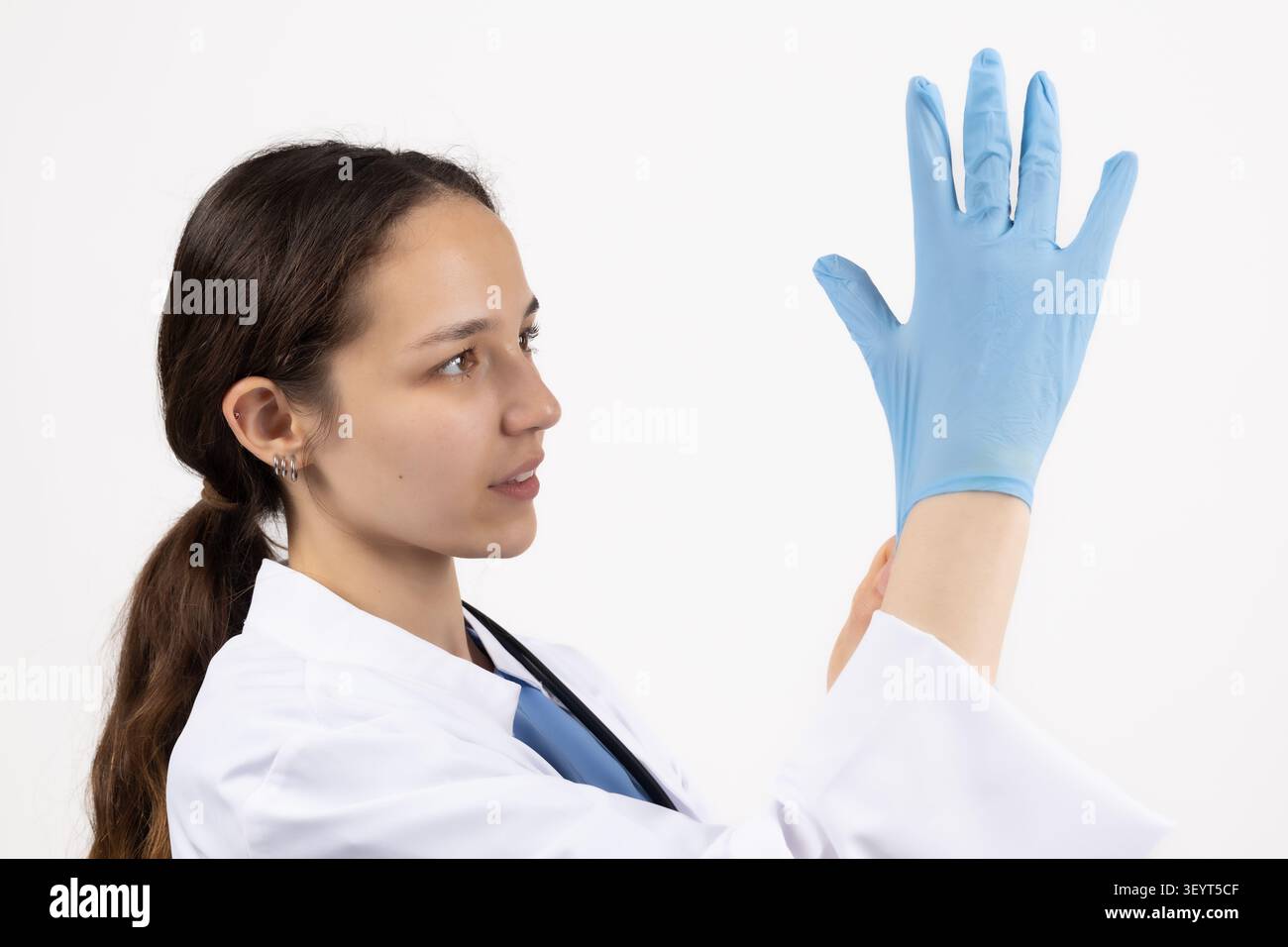 Wissenschaftlerin mit blauen Schutzhandschuhen in einer professionellen Fotostudi... Stockfoto