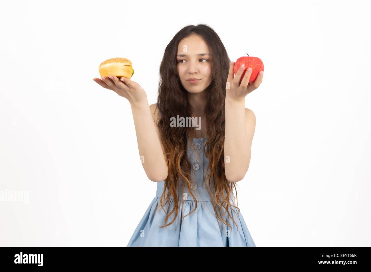 Frau, die Lebensmittel in beiden Händen hält, im Studio in einem professionellen Foto... Stockfoto