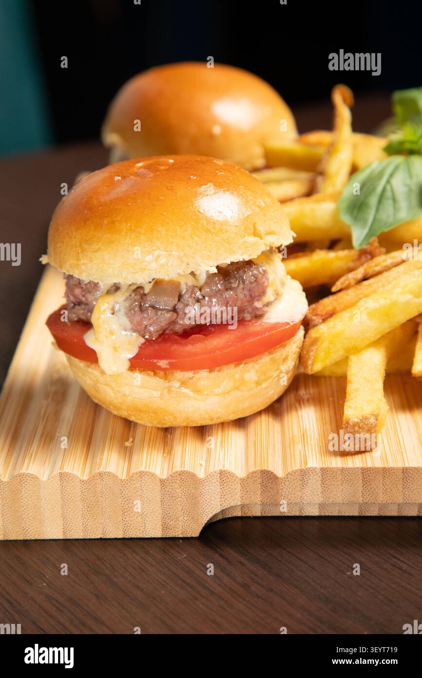 UN plat de Mini Burgers avec frites sur une planche en bois dans un Restaurant Stockfoto