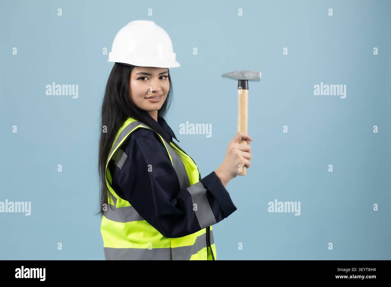 Eine Bauingenieurin hält einen Hammer im Studio auf einem professionellen Foto... Stockfoto