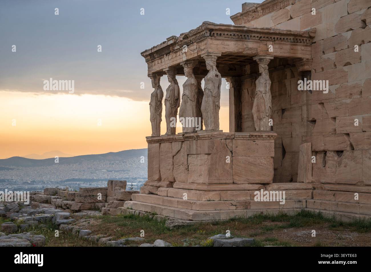 Die Karyatiden, weibliche Statuen auf der Akropolis von Athen, Griechenland, eingerahmt von einem lebhaften Sonnenuntergang Stockfoto