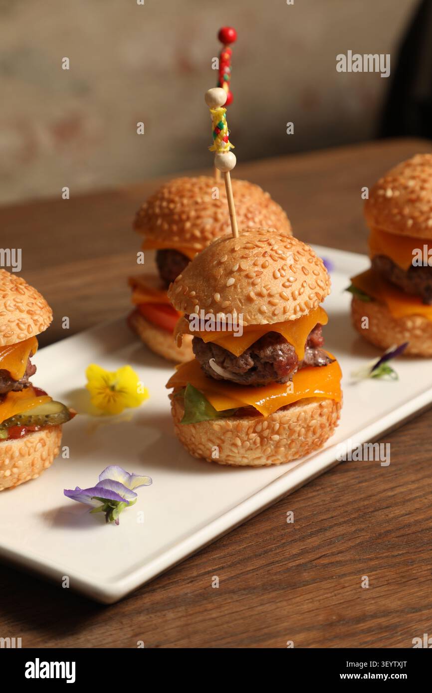 Quatre Mini Hamburger sur un plat blanc. Stockfoto