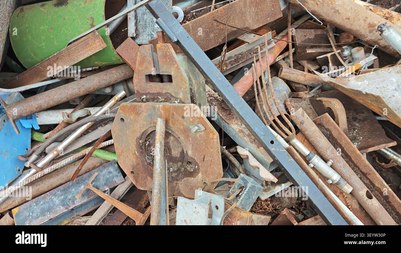 Ein überfüllter Haufen von Industrieschrott, der rostige Rohre, Stahlträger und alte Werkzeuge enthält. Stockfoto