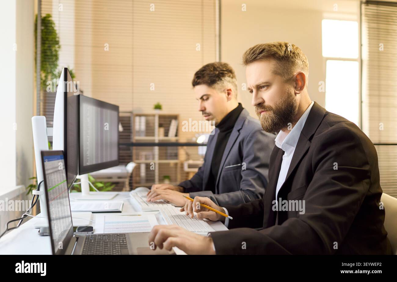Zwei Buchhalter-Teams von Geschäftsanalysten arbeiten an Finanzdaten in modernen Büros Stockfoto