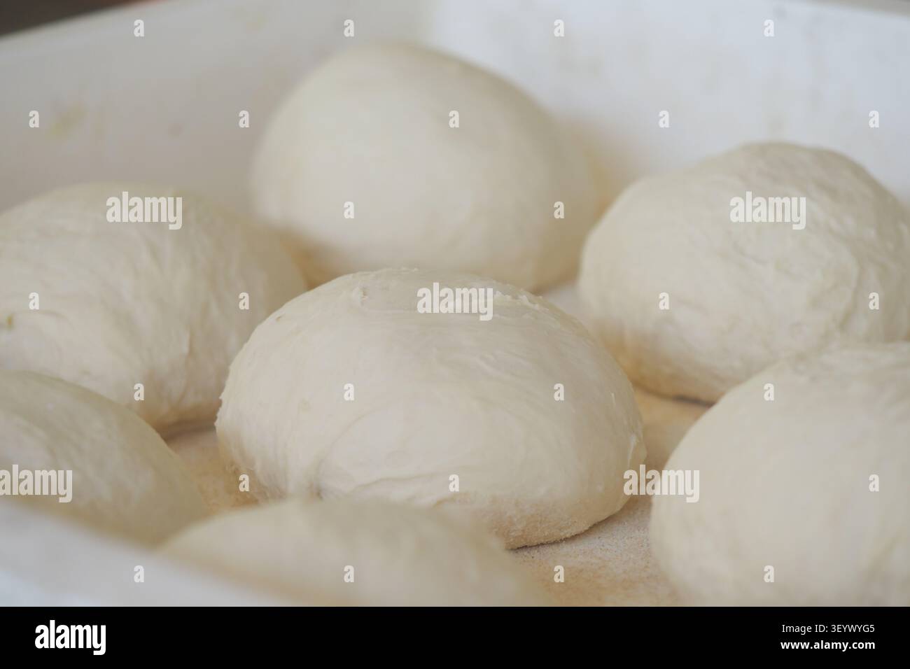 Der Teig liegt in einem Tablett, bevor er in der Küche gebacken wird Stockfoto