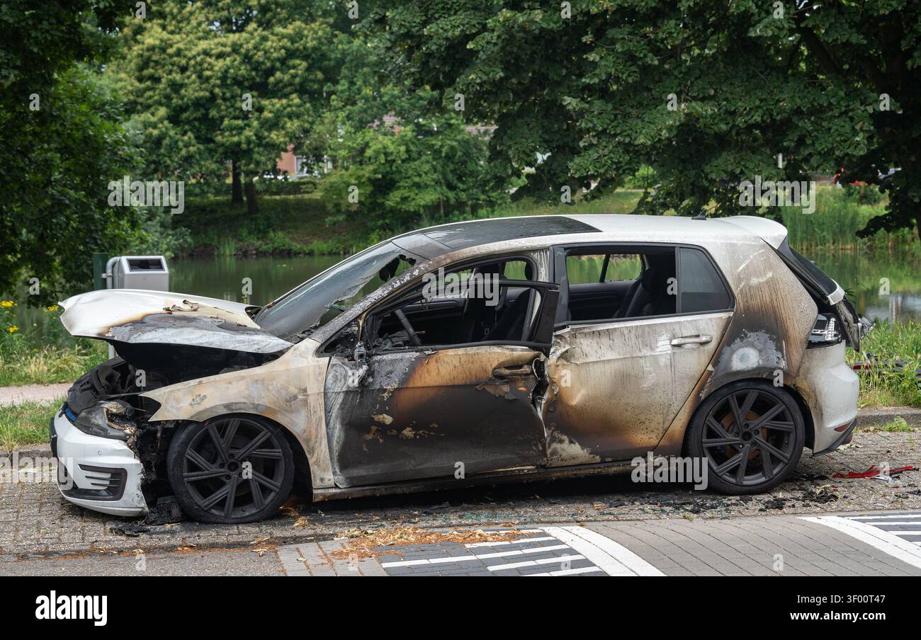 Verbrannte und abgestürzte Autos stehen gelassen am Straßenrand Stockfoto