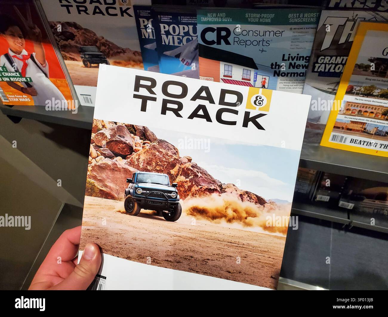 CHICAGO, IL, USA - 15. JULI 2021: Eine Person hält ein Road and Track Magazin mit einem Titelbild eines Autos, das durch eine Wüstenlandschaft fährt. Das mA Stockfoto