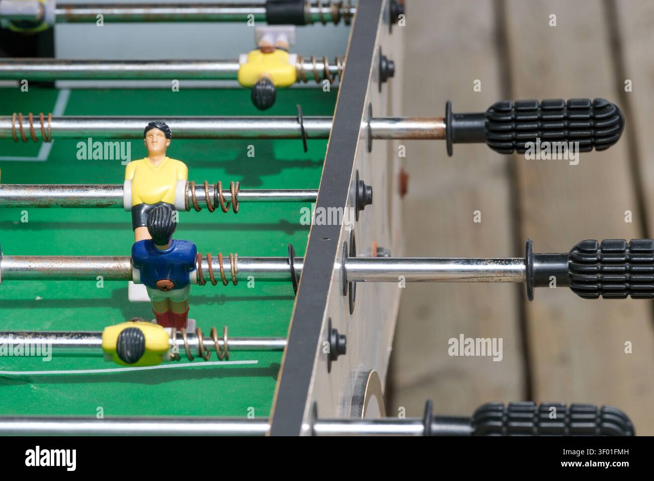 KIEW, UKRAINE, 5. JULI 2026, Nahaufnahme eines Kickertisches mit Minifußballspielern und Steuergriffen in einem Freizeitbereich. Stockfoto