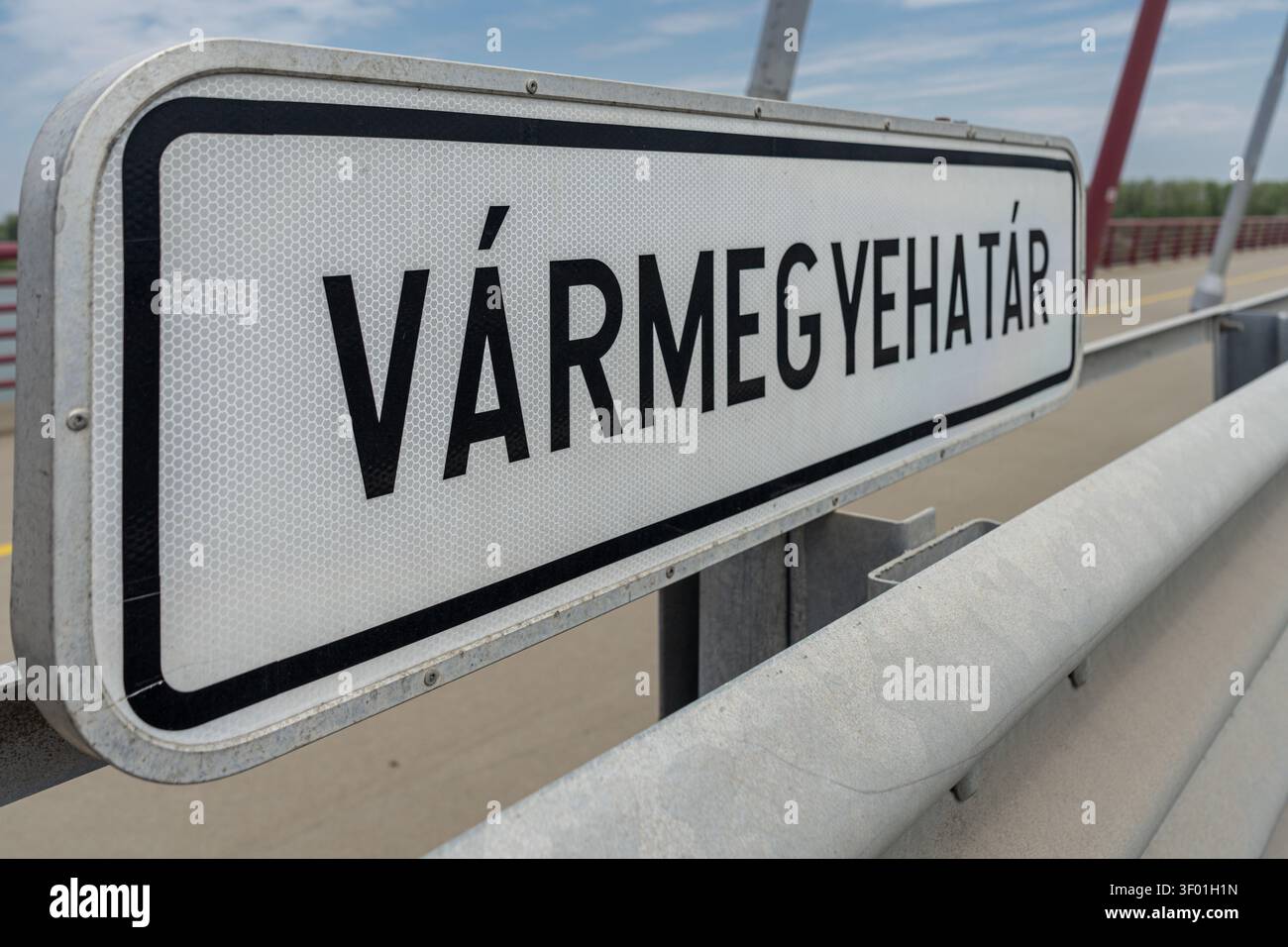 Ein „Varmegyehatar“-Grenzschild steht auf der Pentele-Brücke über die Donau. Stockfoto