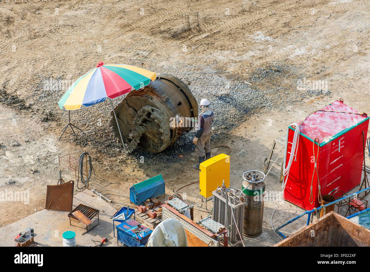 Bauarbeiter, der Schweißarbeiten mit großen Stahlrohren auf der Baustelle in Busan, Südkorea, durchführt. Schwerindustrie, Tiefbau Stockfoto