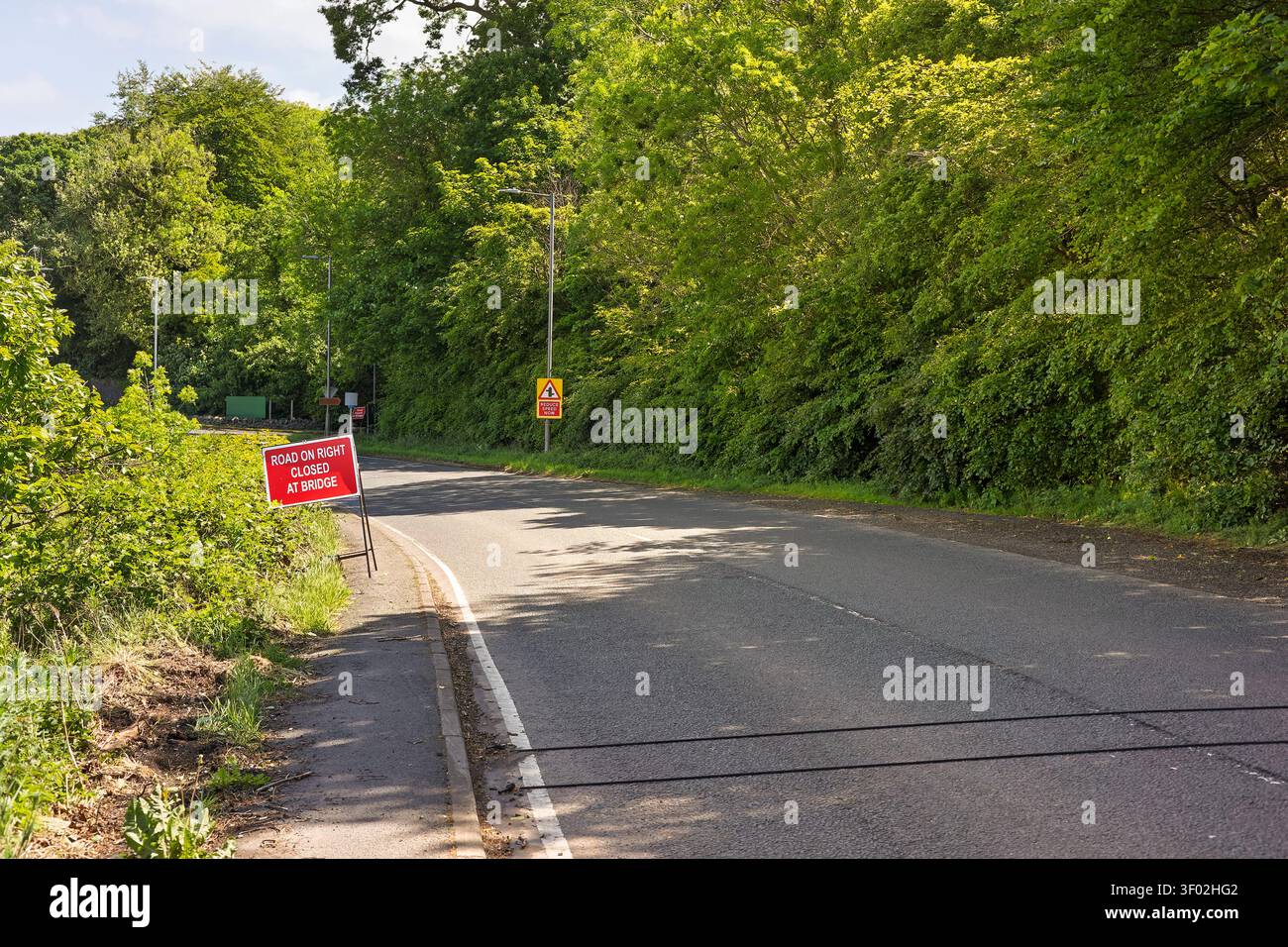 Schwarze pneumatische Straßenrohre, die über eine ruhige Landstraße gesichert sind, um den Verkehr zu zählen, Fahrzeugklassifizierung, Verkehrserhebungen und Autobahndaten zu erfassen Stockfoto