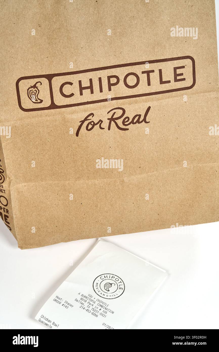 DALLAS, TX, USA – 16. FEBRUAR 2024: Eine Chipotle-Papiertüte mit dem Branding „CHIPOTLE for Real“ ist neben einer gedruckten Quittung auf einem weißen Hintergrund zu sehen Stockfoto
