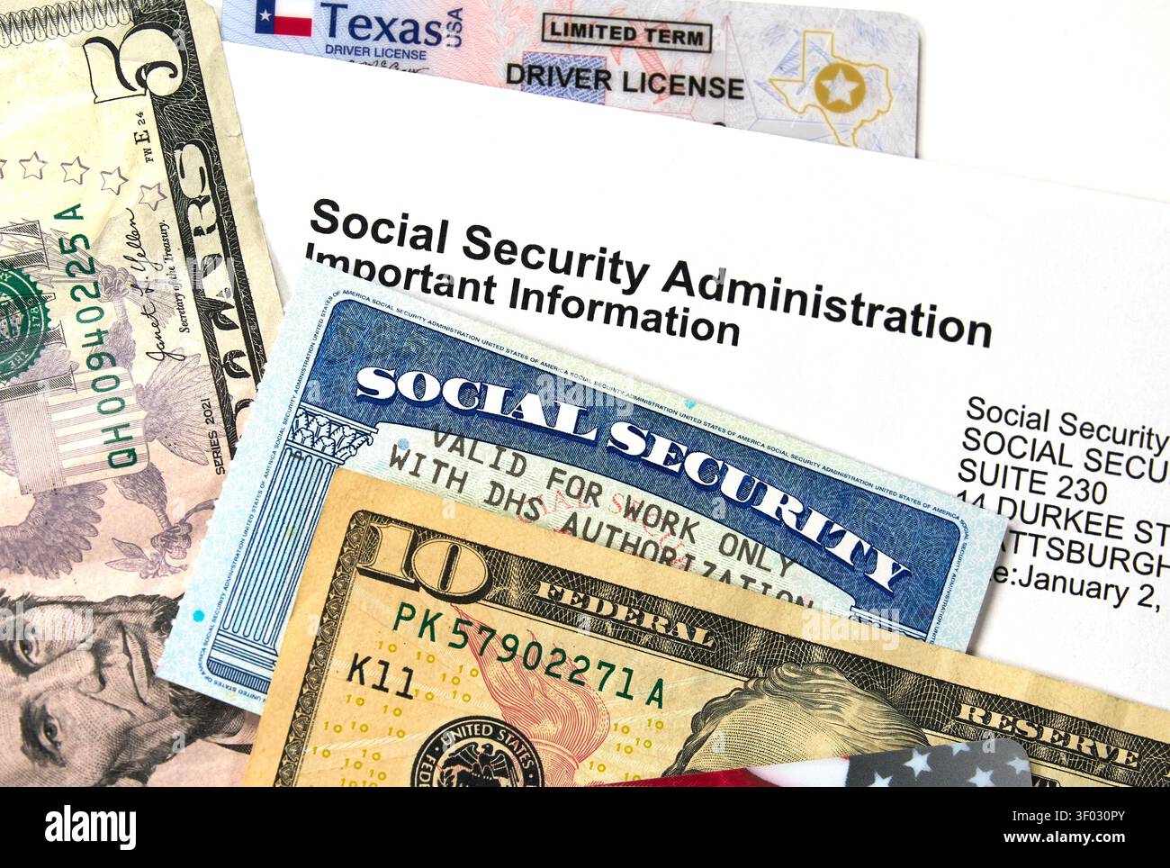 CARROLLTON, TX, USA - 22. FEBRUAR 2024: Eine Komposition mit einer offiziellen Sozialversicherungskarte auf US-Währung und Dokumentation. Die Abbildung zeigt Stockfoto