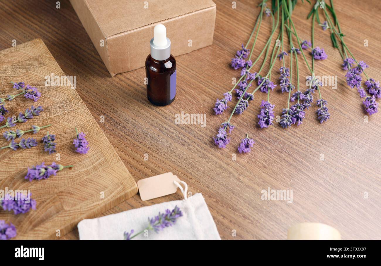 Lavendelölflasche und Beutel mit Blumen auf Holzbrett. Flache Komposition für Social-Media-Content-Ersteller und Blogging-Hintergrund Stockfoto