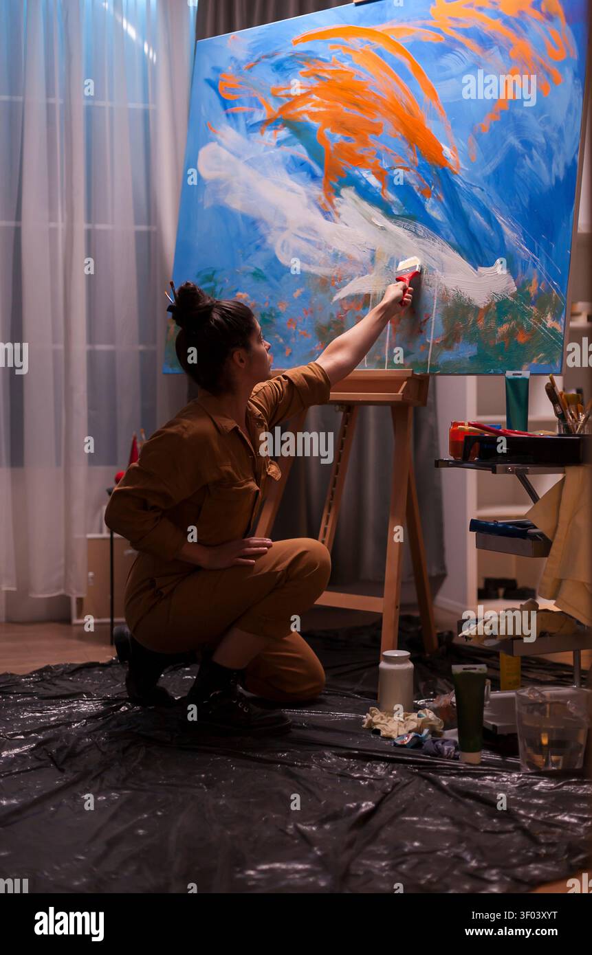 Die Künstlerin malt impressionistische Leinwand im Studio mit Leinwand, Pinsel und kreativem Fokus und zeigt zeitgenössische Malpraxis, Atelierarbeit und künstlerische Produktion Stockfoto