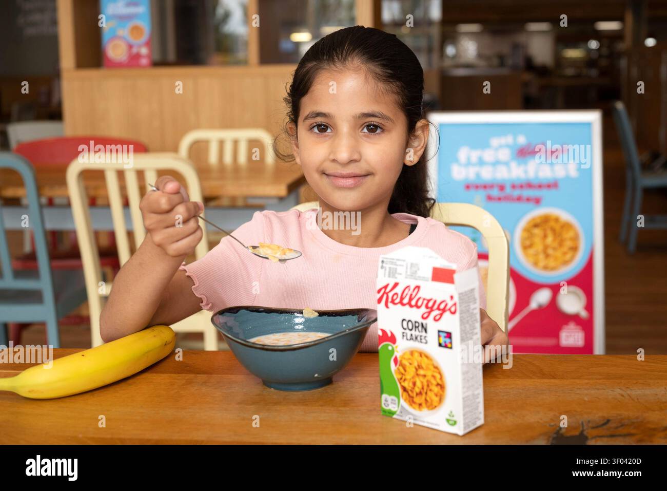 NUR Ein Kind (Name nicht angegeben) frühstückt in einem Morrisons Café in Chingford, da der Supermarkt mit Kellogg's zusammenarbeitet, um seine Schulferien „Breakfast Clubs“ neu zu beleben, die Familien in den Sommerferien in ganz Großbritannien kostenlose Mahlzeiten anbieten. Ausgabedatum: Montag, 6. Juli 2026. Stockfoto