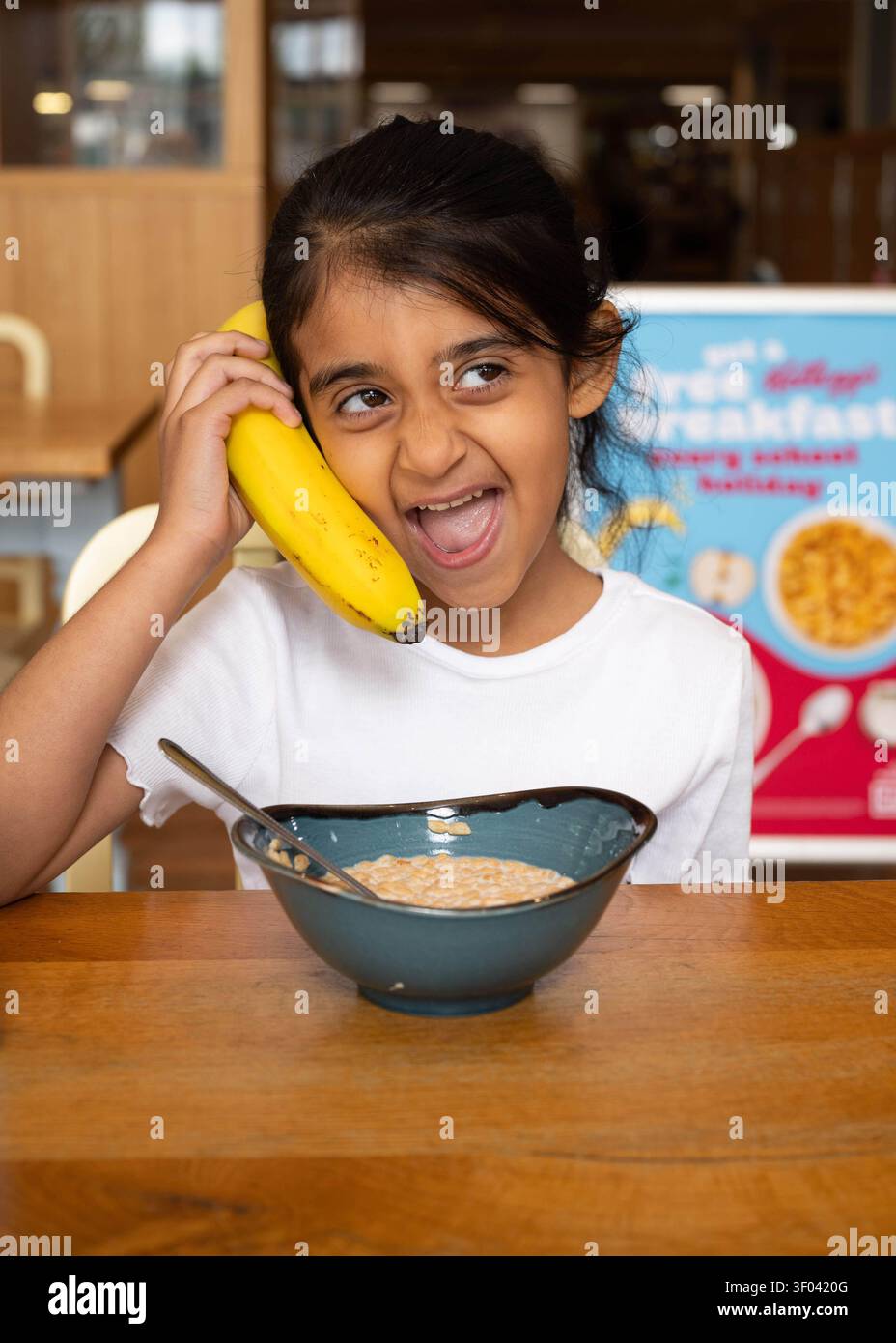 NUR Ein Kind (Name nicht angegeben) frühstückt in einem Morrisons Café in Chingford, da der Supermarkt mit Kellogg's zusammenarbeitet, um seine Schulferien „Breakfast Clubs“ neu zu beleben, die Familien in den Sommerferien in ganz Großbritannien kostenlose Mahlzeiten anbieten. Ausgabedatum: Montag, 6. Juli 2026. Stockfoto