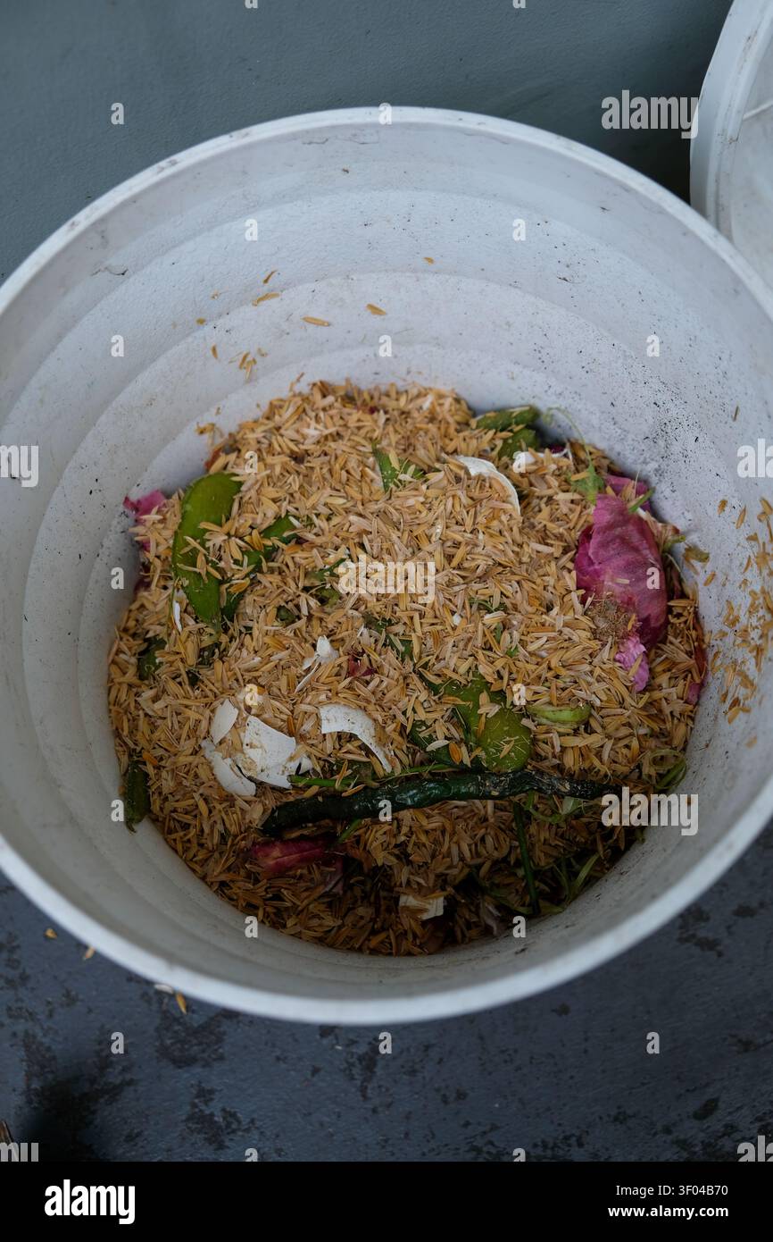 Ein kreativer DIY Blumentopf Kompostbehälter, der Küchenreste auf einem kleinen Balkon recycelt Stockfoto