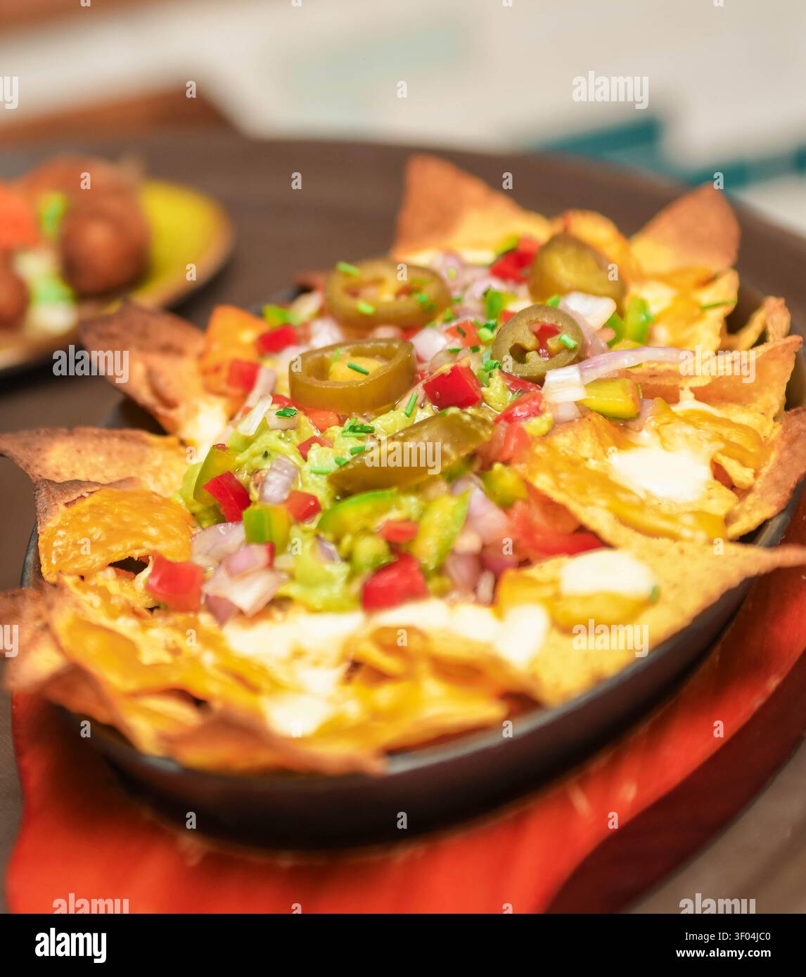 Nachos mit Käse, Guacamole und Jalapenos Stockfoto