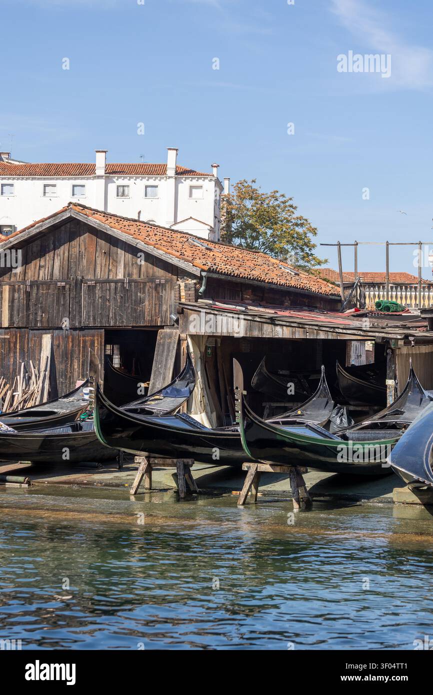 Gondolas in einer Werkstatt in Venedig an einem sonnigen Tag am Wasser Stockfoto