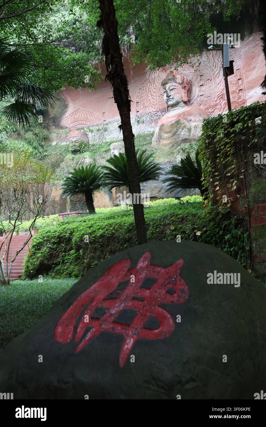 Buddha-Statue, die aus dem Berg gehauen ist, und ein großer Stein mit rotem Wort: Fó als Bedeutung von Buddha im Oriental Buddha Park, Leshan, Sichuan, China Stockfoto