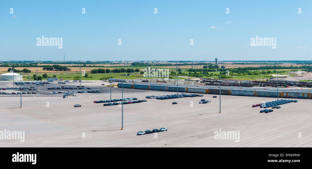 Hutto, TX - 7. April 2026: Luftaufnahme eines großen Industrieparkplatzes und Verladebereichs für Tesla-Elektroautos auf benachbarte Eisenbahngüterwagen Stockfoto