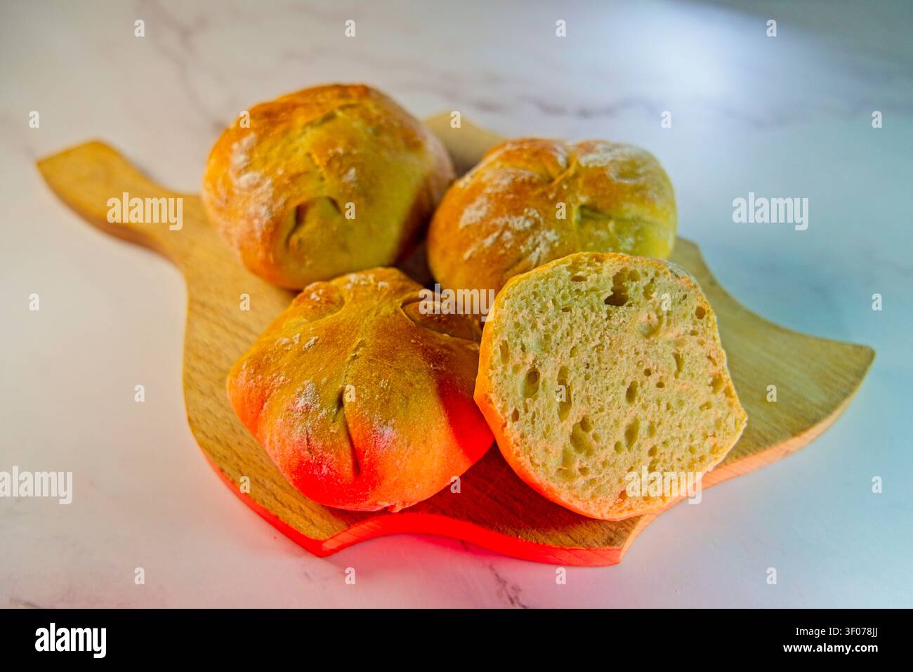 Geschnittenes Brötchen auf einem Holzbrett Stockfoto