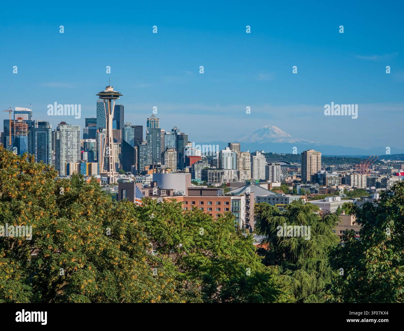 Panoramablick auf die Skyline der Innenstadt von Seattle mit Mount Rainier im Hintergrund, mit Wolkenkratzern und Stadtlandschaft unter einem klaren blauen Himmel. Stockfoto
