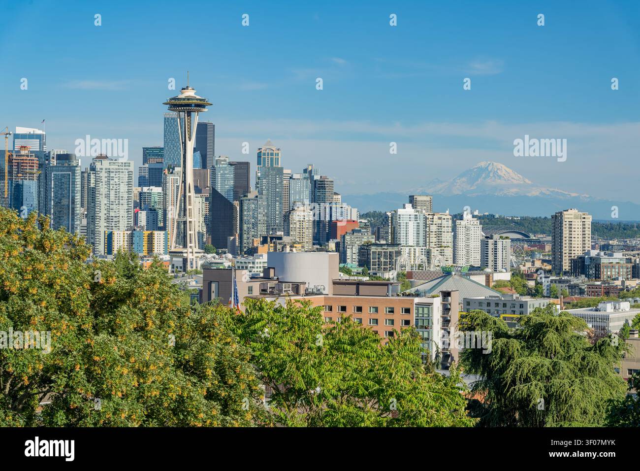 Panoramablick auf die Skyline der Innenstadt von Seattle mit Mount Rainier im Hintergrund, mit Wolkenkratzern und Stadtlandschaft unter einem klaren blauen Himmel. Stockfoto