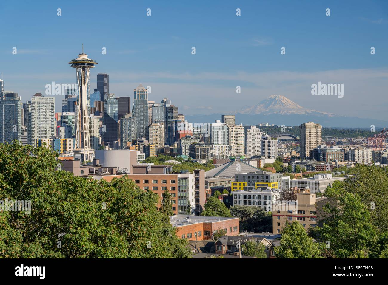 Panoramablick auf die Skyline der Innenstadt von Seattle mit Mount Rainier im Hintergrund, mit Wolkenkratzern und Stadtlandschaft unter blauem Himmel. Stockfoto