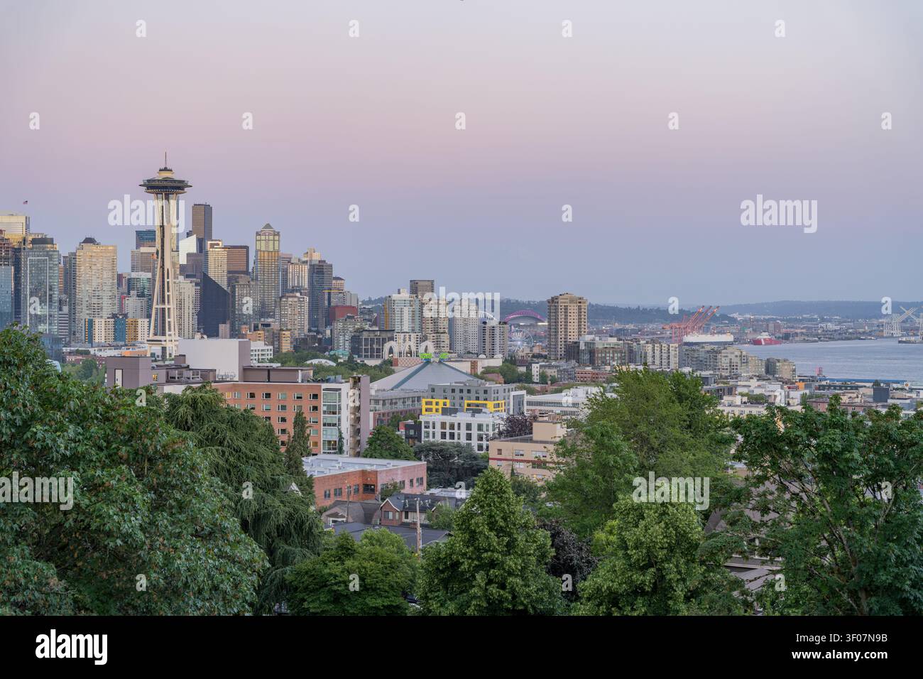 Panoramablick bei Dämmerung auf die Skyline von Seattle und die Uferpromenade mit Wolkenkratzern, Bucht und Stadtlandschaft in sanften Dämmerungsfarben. Stockfoto