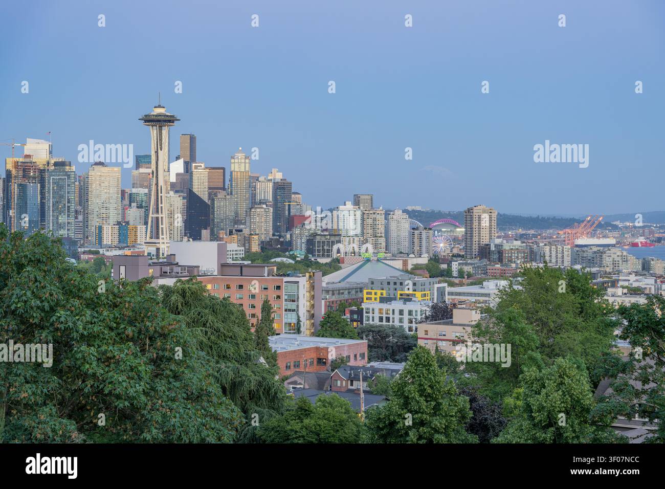 Panoramablick auf die Skyline von Seattle und die Uferpromenade, mit Wolkenkratzern, Bucht und Stadtlandschaft unter blauem Himmel. Stockfoto