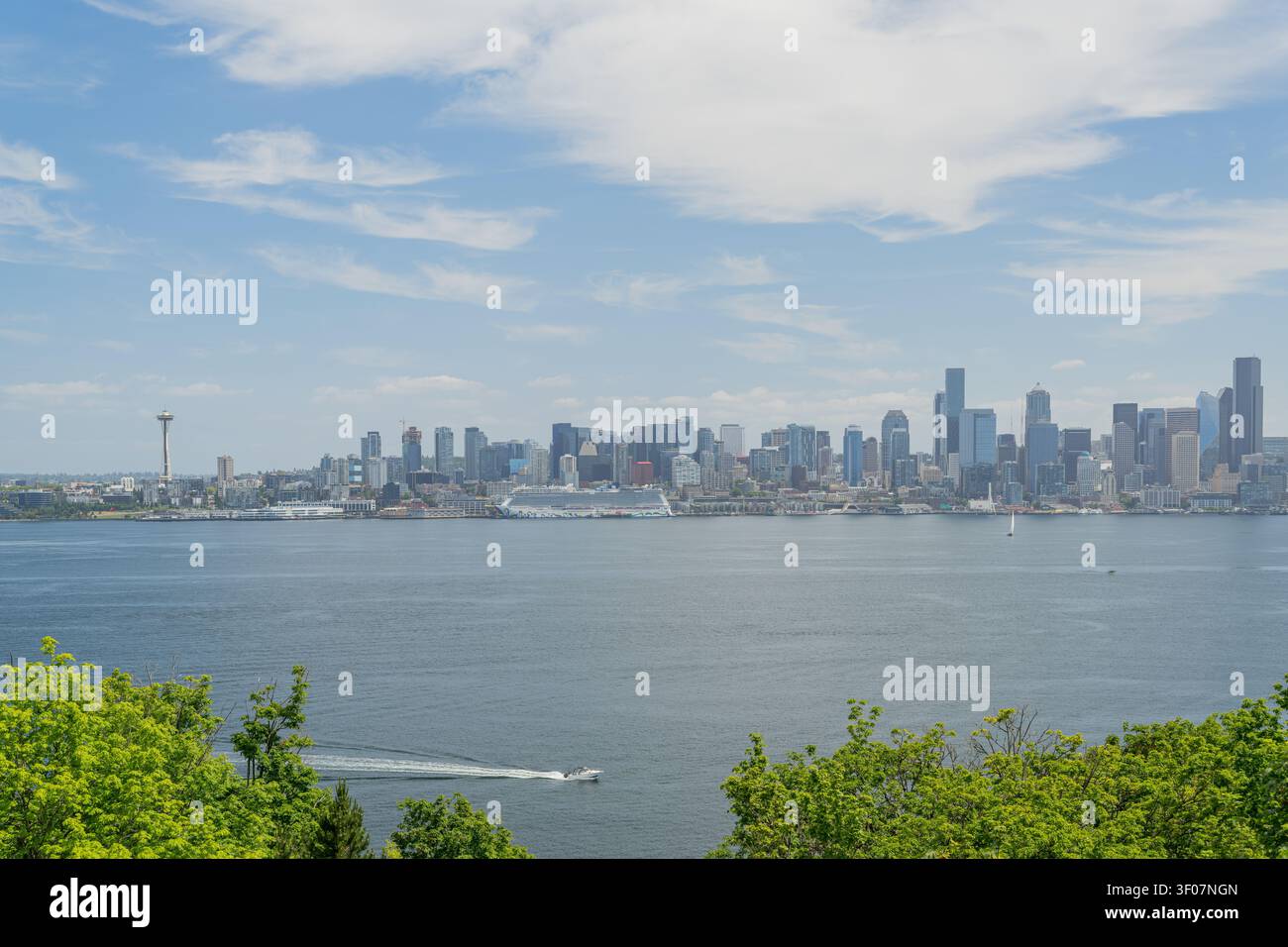 Panoramablick auf die Skyline der Innenstadt von Seattle über den Puget Sound, mit Wasser, Wolkenkratzern und Stadtlandschaft unter blauem Himmel. Stockfoto