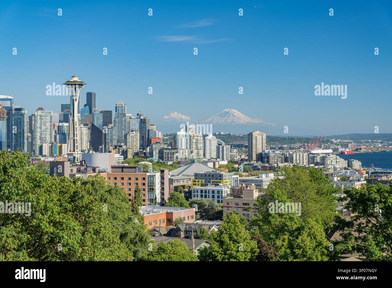 Panoramablick auf die Skyline der Innenstadt von Seattle mit Mount Rainier im Hintergrund, mit Wolkenkratzern und Stadtlandschaft unter blauem Himmel. Stockfoto