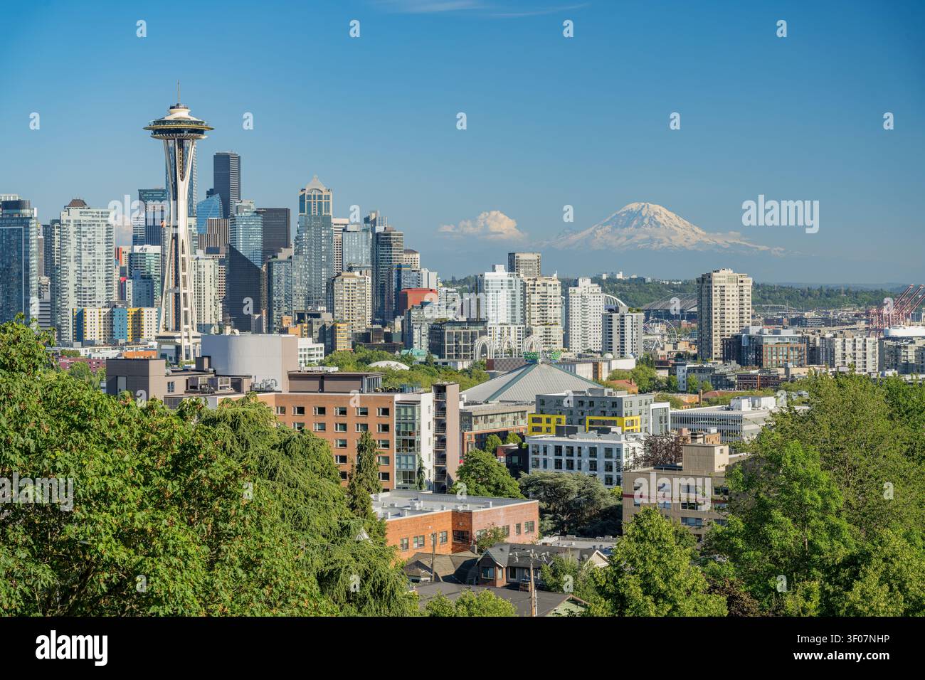 Panoramablick auf die Skyline der Innenstadt von Seattle mit Mount Rainier im Hintergrund, mit Wolkenkratzern und Stadtlandschaft unter blauem Himmel. Stockfoto