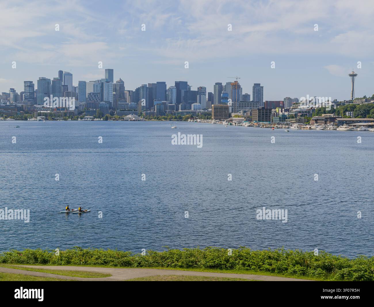 Panoramablick auf die Skyline der Innenstadt von Seattle vom Lake Washington aus, mit Wasser, Paddelboardern, Wolkenkratzern und Stadtlandschaft unter einem B Stockfoto
