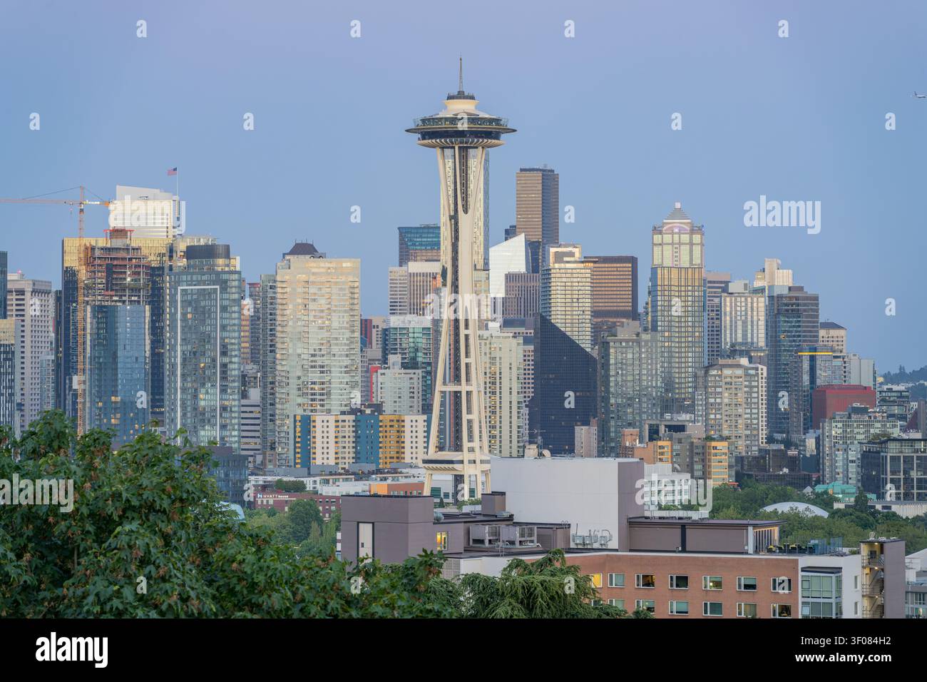 Washington Staat, Vereinigte Staaten, 20. JUNI 2026 - Der Space Needle ragt markant zwischen den Wolkenkratzern der Innenstadt von Seattle hervor, mit Grün Stockfoto