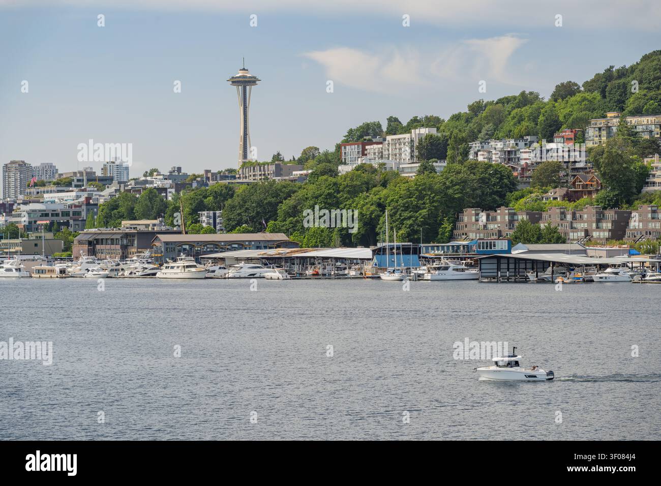Washington State, JUN 21, 2026 - Eine Ansicht der Seattle-Skyline mit dem Space Needle und einem Yachthafen voller festgemachter Boote entlang der Uferpromenade Stockfoto
