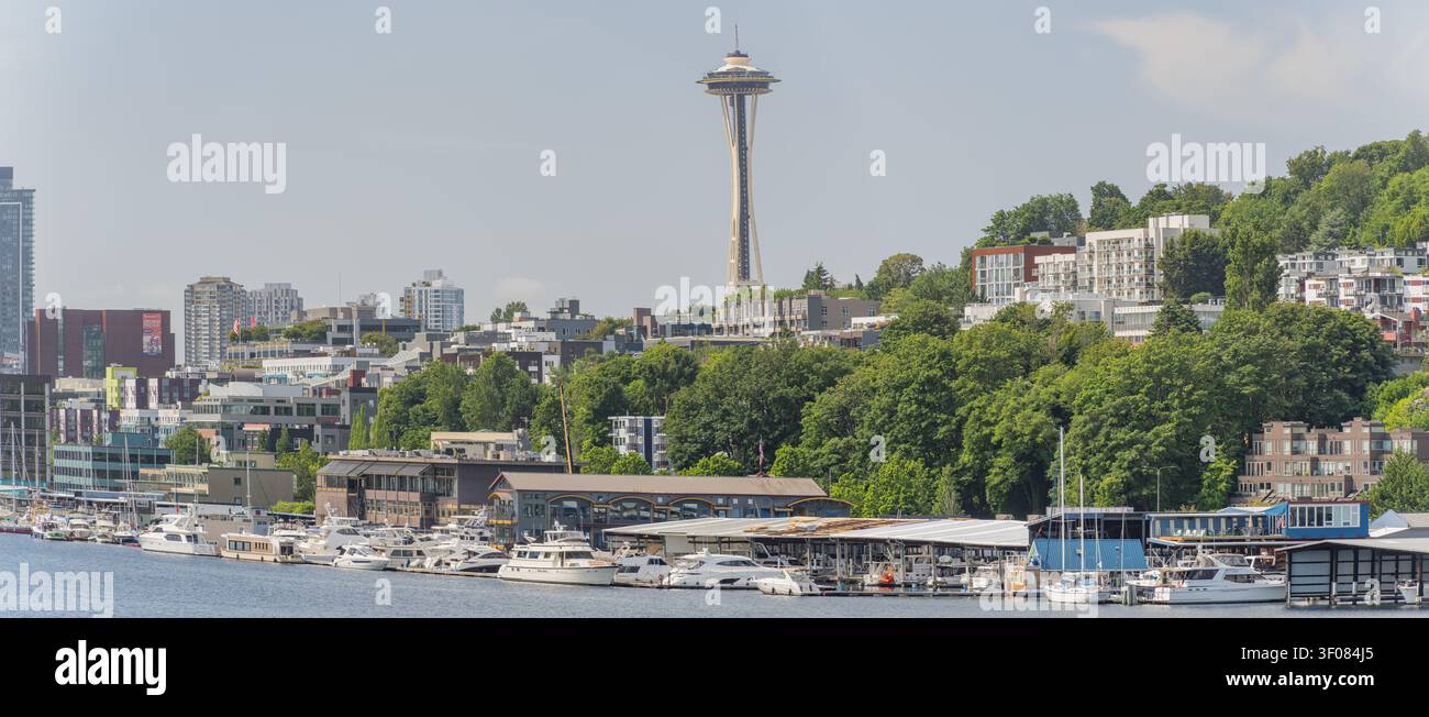 Washington State, JUN 21, 2026 - Blick auf die Seattle Space Needle, die über einer Stadtsilhouette und einem Yachthafen mit gedockten Booten und üppigem Grün aufragt Stockfoto