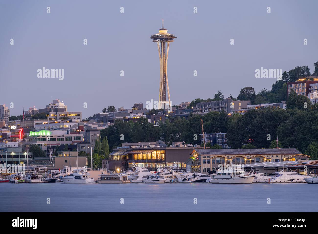 Washington State, JUN 21, 2026 - Blick auf den Space Needle-Turm, der über der Skyline von Seattle aufragt, mit einem Yachthafen voller weißer Yachten und Boote im Stockfoto