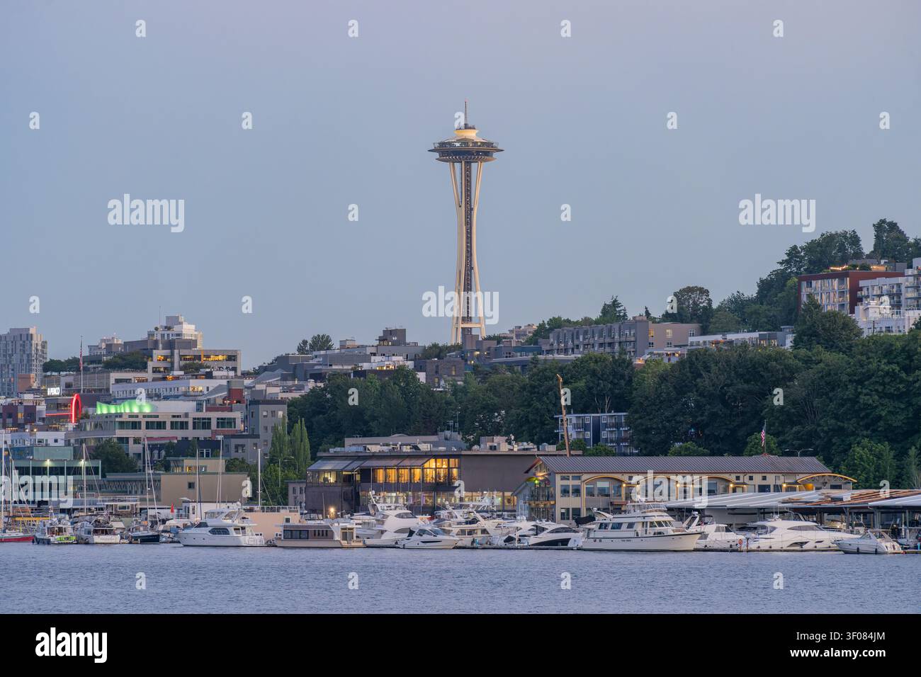Washington State, JUN 21, 2026 - Die ikonische Space Needle erhebt sich über der Skyline von Seattle und einem Yachthafen voller festgemachter Boote entlang der Uferpromenade Stockfoto