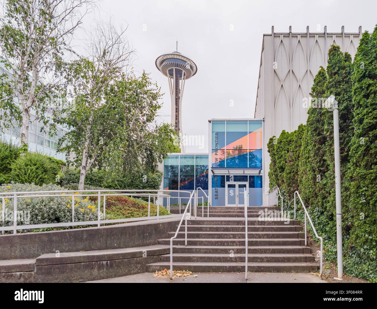 Washington State, USA, 20. JUN 2026 - Betontreppen mit weißem Geländer führen zu einem Eingangsgebäude aus Glas mit Schildern zum Seattle Center. Stockfoto