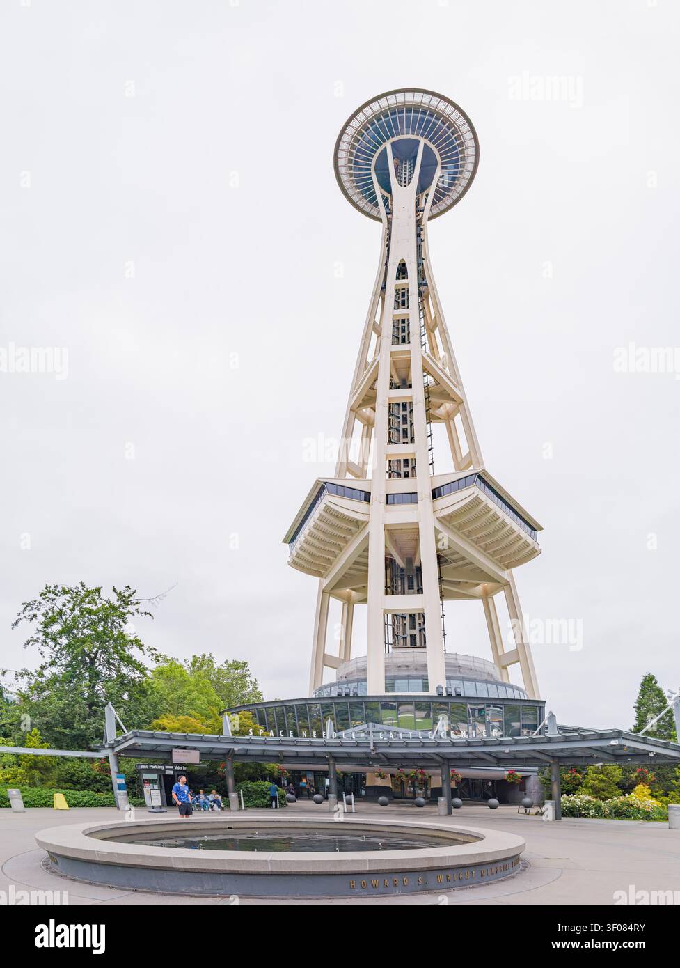 Washington State, USA, 20. Juni 2026 - Niedrigwinkelblick auf den legendären Space Needle Tower mit einem runden Brunnen und Eingang i des Besucherzentrums Stockfoto