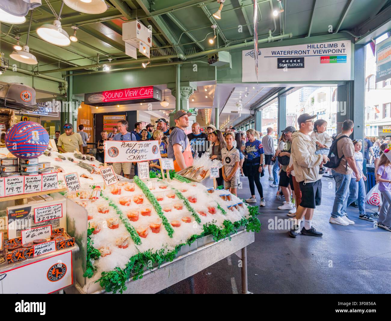 Washington State, USA, 21. Juni 2026 - geschäftiger Fischmarkt mit frischem Lachs und Meeresfrüchten auf Eis, auf dem eine Reihe von Kunden wartet Stockfoto