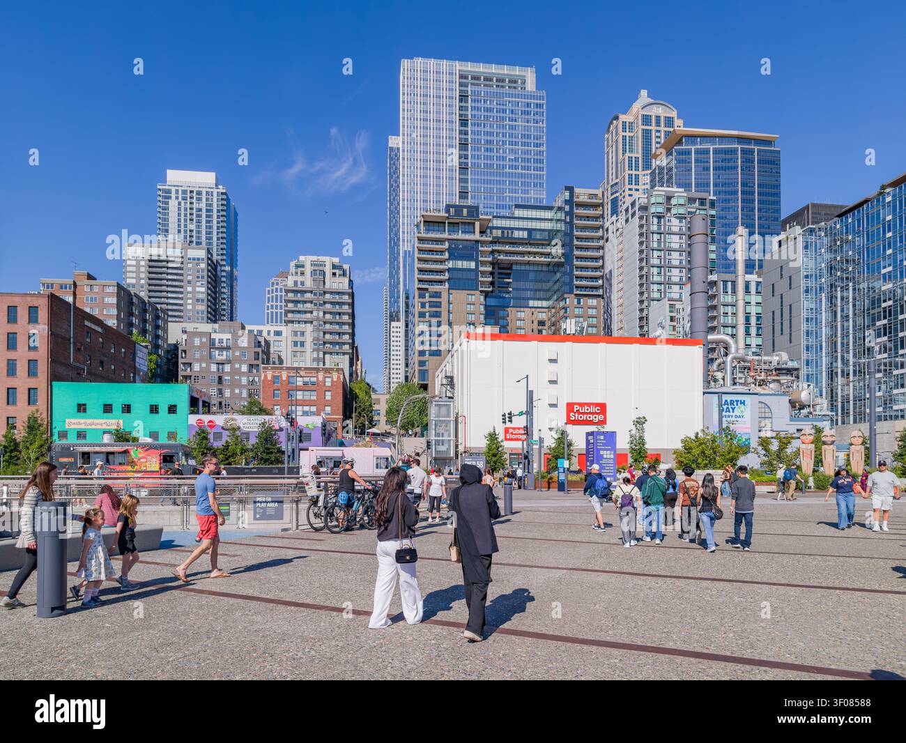 Washington State, USA, 21. Juni 2026 - Fußgänger spazieren über eine gepflasterte plaza in Seattle, Washington, mit modernen Wolkenkratzern und einer öffentlichen S Stockfoto