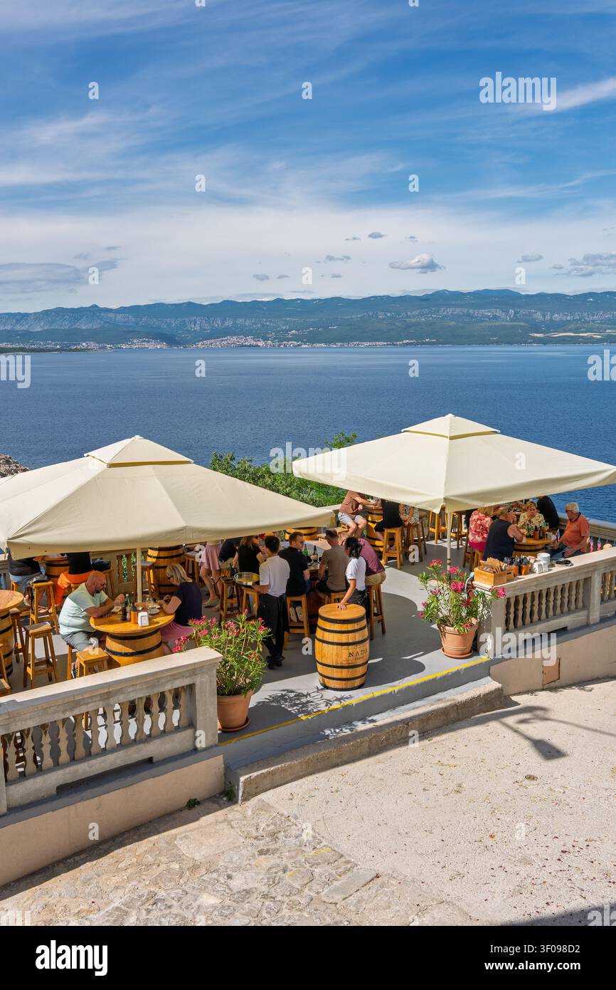 entspannte Außencafeszenen mit Menschen, die auf einer Seeterrasse essen und sich unterhalten, Hochwinkelaufnahme vom Steinweg, der zur Terrasse führt, mit Stockfoto