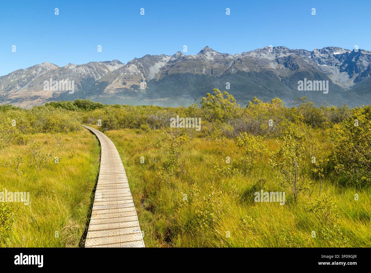 Ein hölzerner Promenadenweg durch den Glenorchy Lagoon Scenic Walkway mit atemberaubender Berglandschaft im Hintergrund, Glenorchy, Otago, Neuseeland Stockfoto