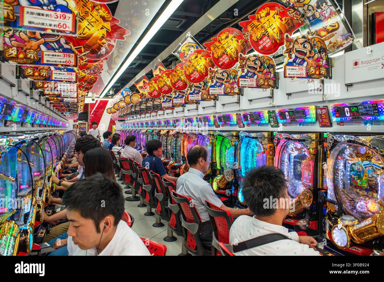 Innenraum eines Pachinko-Arcades in Akihabara, Chiyoda City, Tokio, Japan. Reihen hell beleuchteter Pachinko-Maschinen füllen dieses geschäftige Spielarcade i Stockfoto