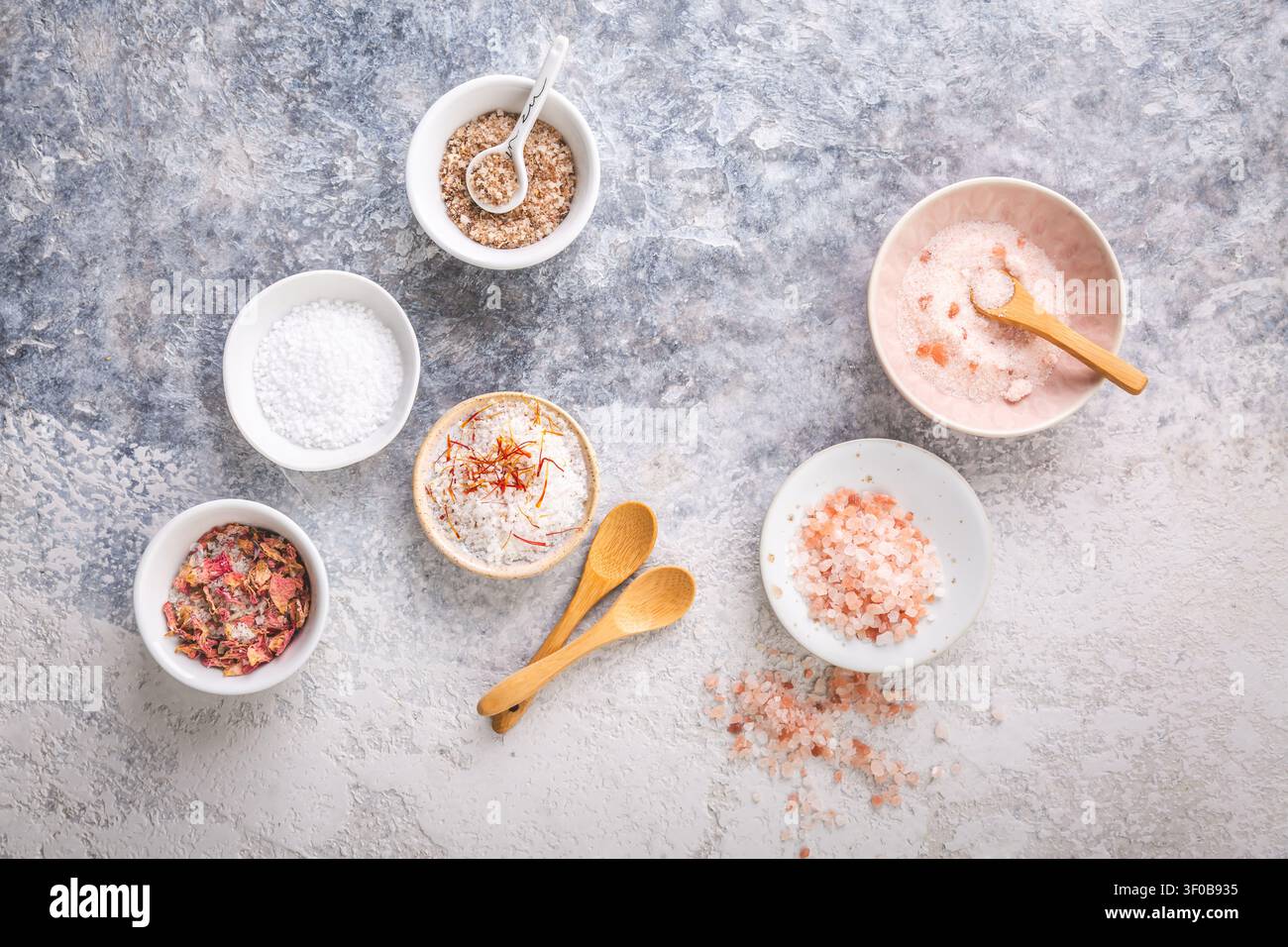Auswahl an Gourmet-Salzen in kleinen Schüsseln, einschließlich Himalaya- und Rosenblüteninfusion Stockfoto