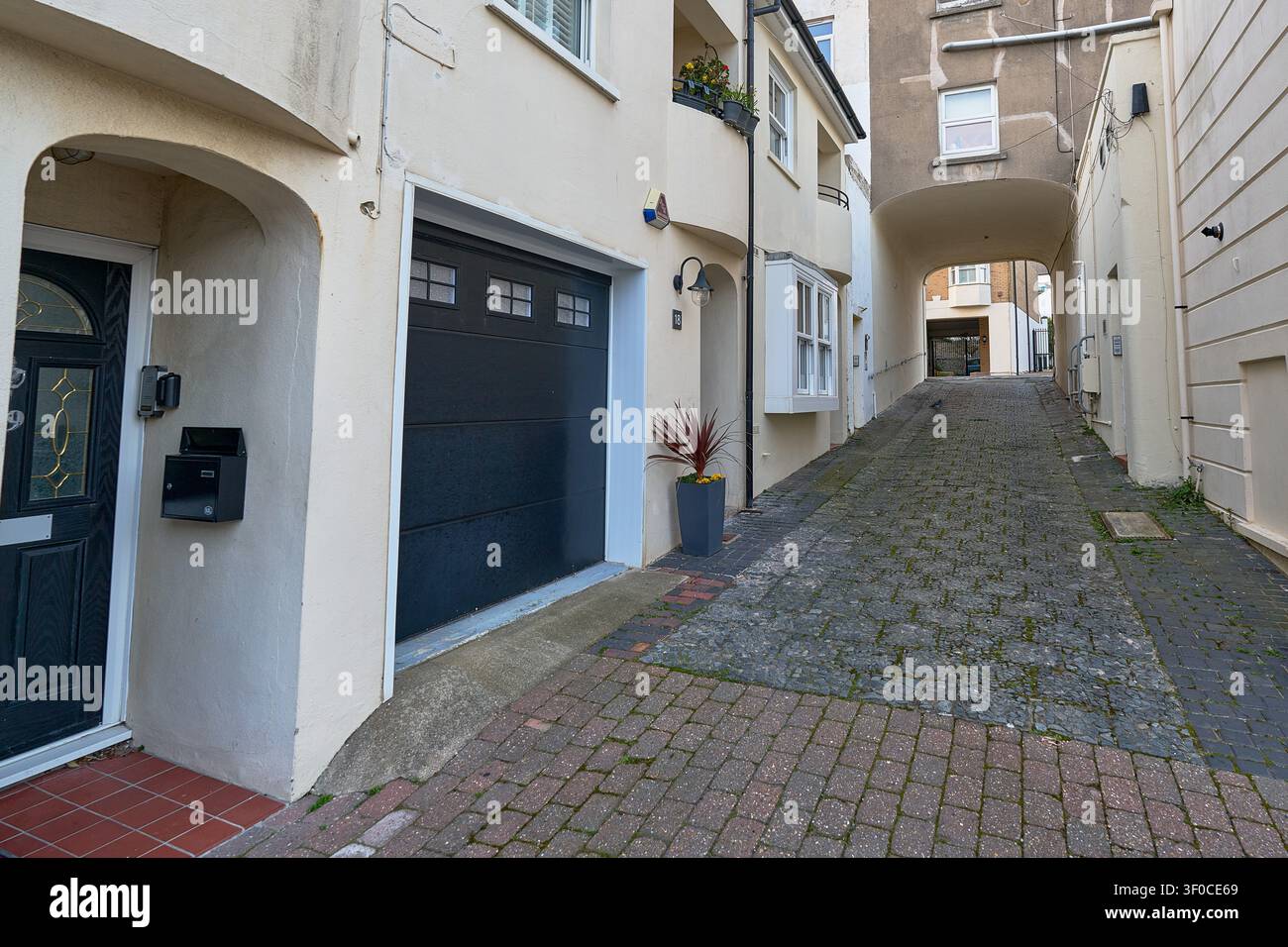 Schmale Kopfsteinpflastergasse zwischen traditionellen Häusern in einer historischen Küstenstadt. Stockfoto